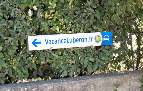 Au 59 chemin de Peliboux, un panneau est plac&eacute; au d&eacute;but du passage en tout-venant &agrave; emprunter pour parvenir &agrave; VacanceLuberon.fr.